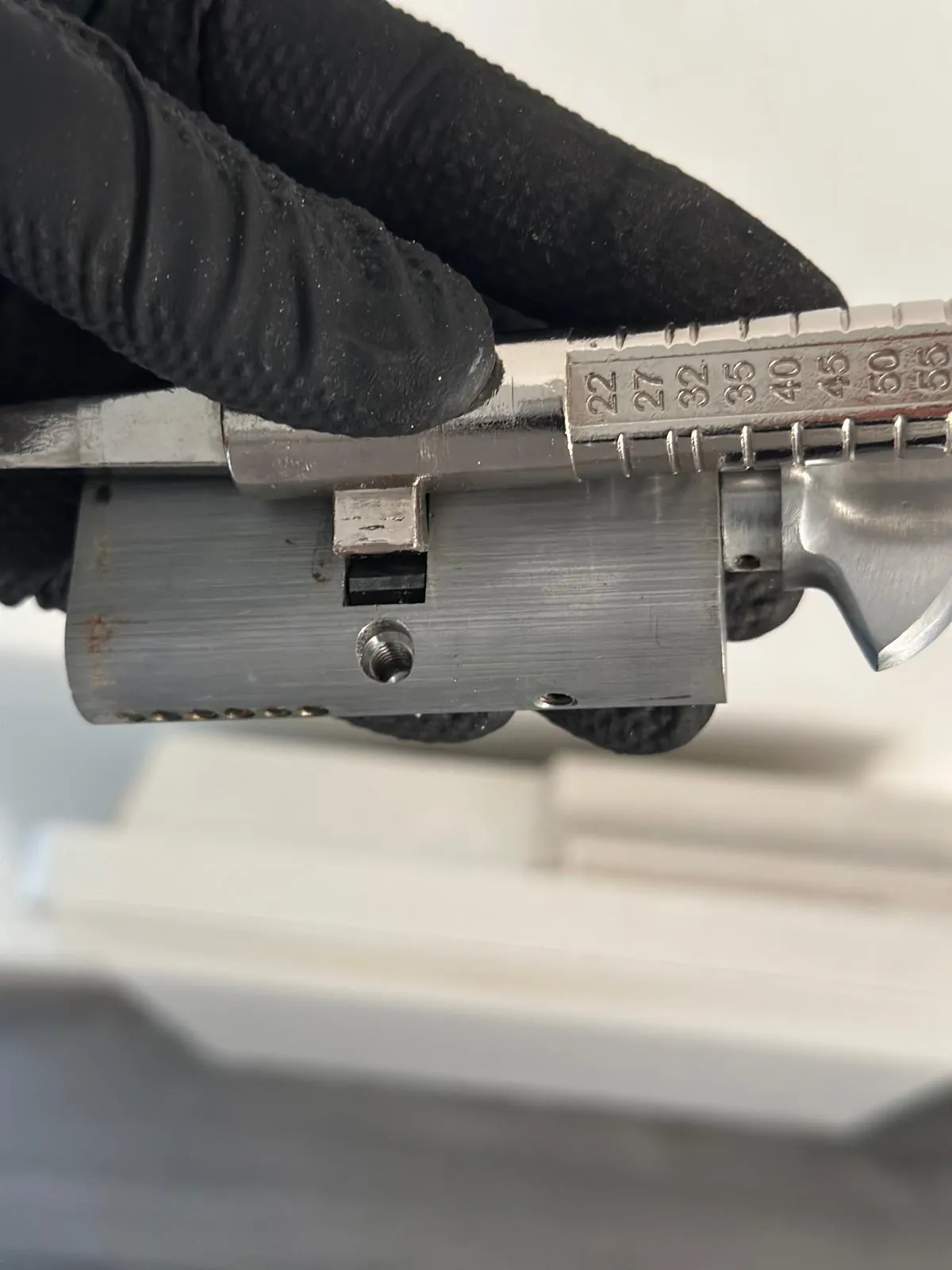 A Euro-profile cylinder being measured with a ruler.