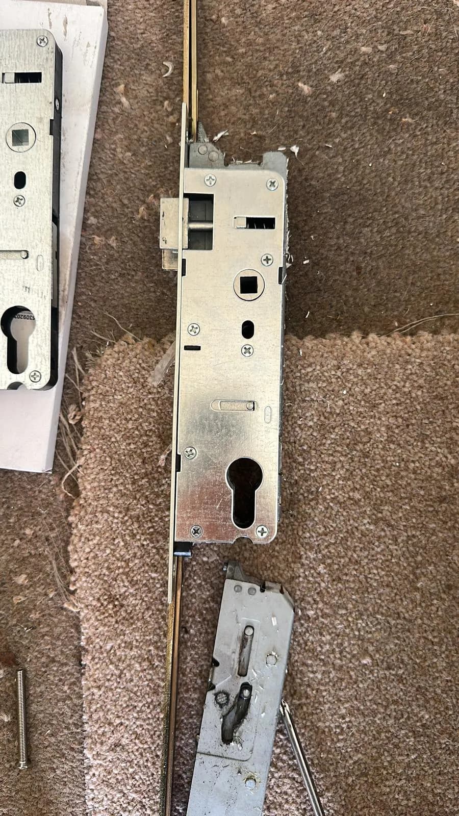 A removed door lock mechanism laid on a floor.